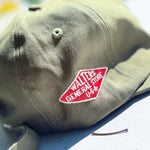 An olive green baseball cap with a red embroidered patch reading 'WALTERS GENERAL STORE U.S.A