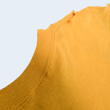 Close-up detail of a mustard yellow ribbed knit garment, showing the neckline and fabric texture against a light gray background.